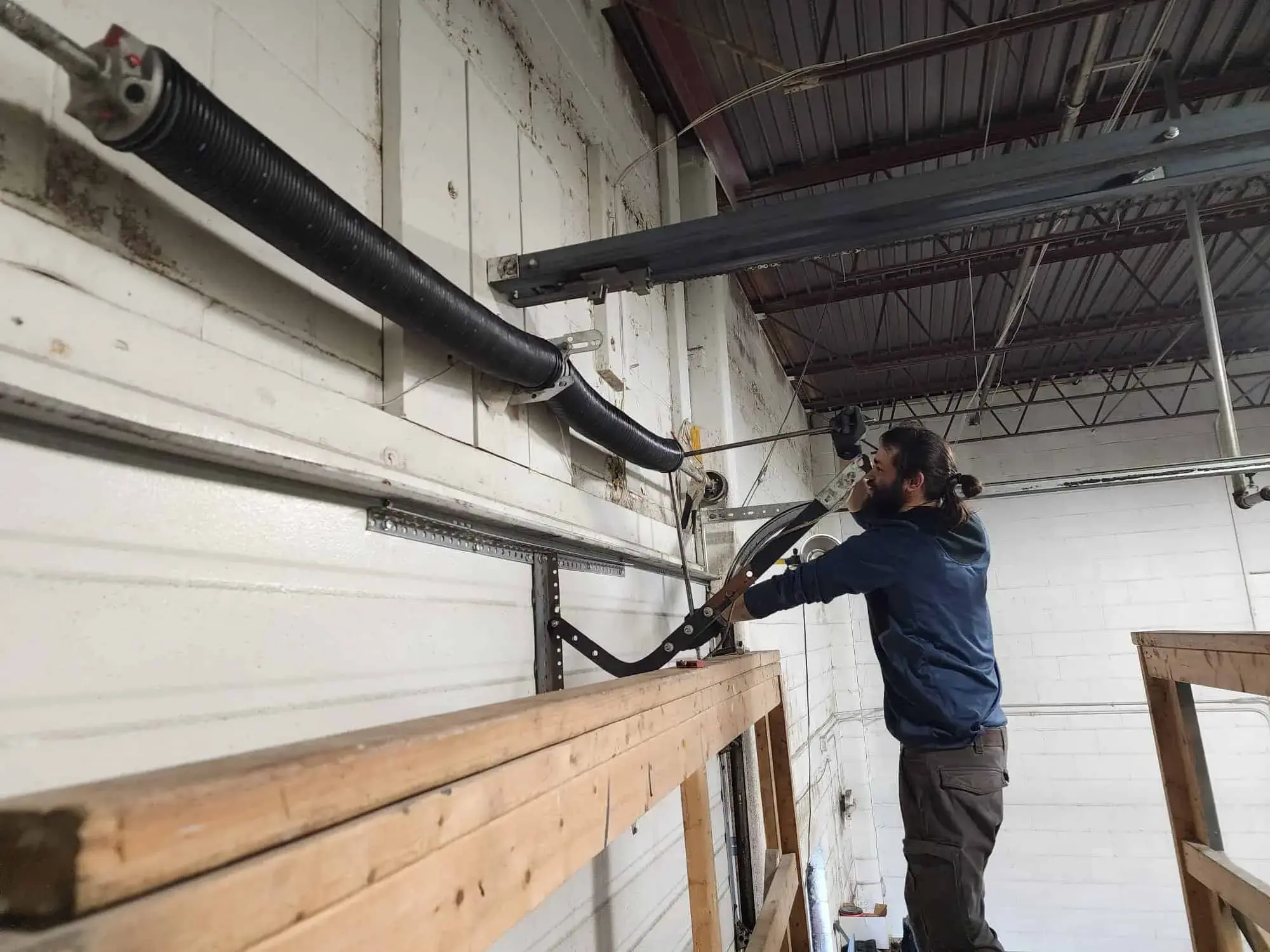 Technician inspecting a garage door to estimate garage door roller replacement cost